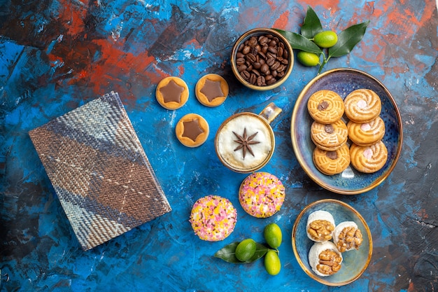 遠いお菓子からの上面図ボウル柑橘系の果物のテーブルクロスで食欲をそそるクッキーコーヒー豆