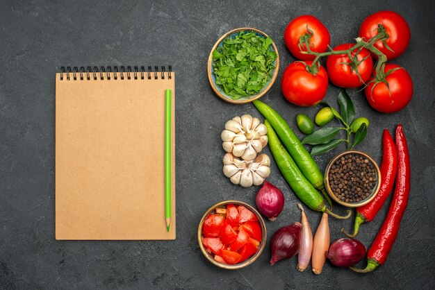 Top view from afar vegetables vegetables herbs spices onion hot pepper notebook pencil