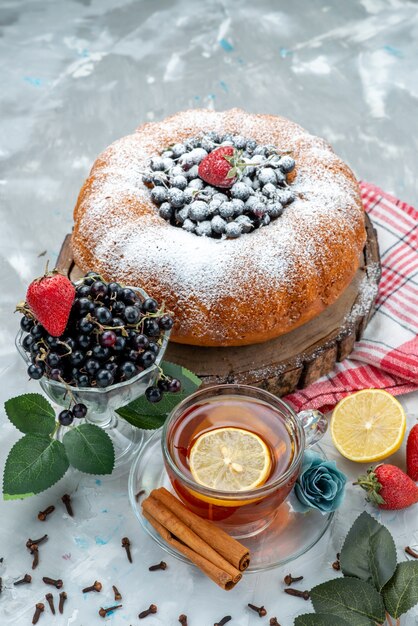 A top view fruit cake delicious and round formed with fresh blue, berries on dark, cake biscuit sweet sugar