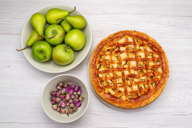 A top view fruit cake round delicious with apples and pears on the light desk cake biscuit fruit flower