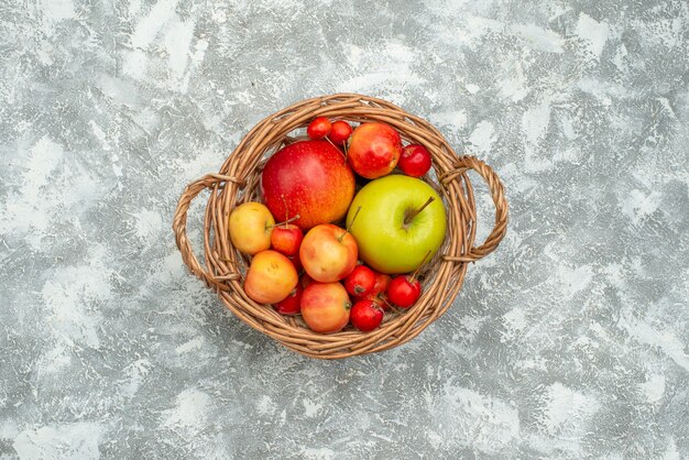 Вид сверху фруктовая композиция, разные свежие фрукты внутри корзины на белом пространстве
