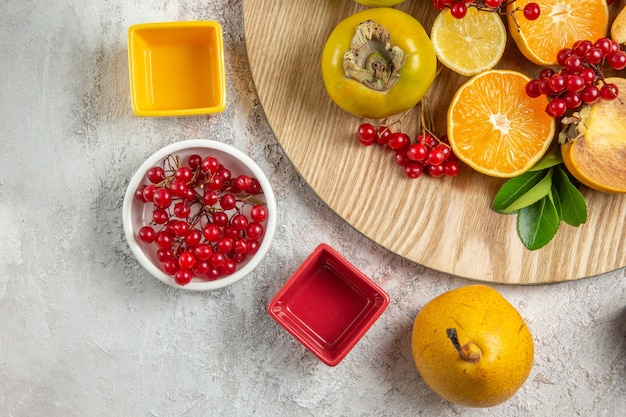 Foto gratuita vista superiore della composizione nella frutta frutti diversi sulla tavola bianca frutti di bosco freschi maturi