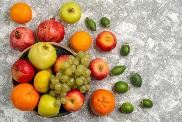 Вид сверху фруктовая композиция фейхоа, мандарины и яблоки на белой поверхности спелые фрукты витамин мягкий свежий