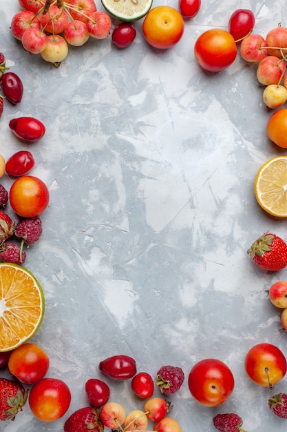 Foto gratuita composizione nella frutta di vista superiore limoni prugne e ciliegie sulla vitamina pastosa fresca matura della frutta bianca dello scrittorio