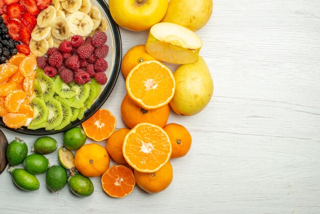 Top view fruit composition with sliced fruit salad on white background
