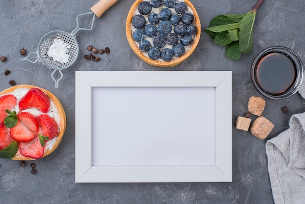 Top view of fruit tarts with frame and sugar cubes