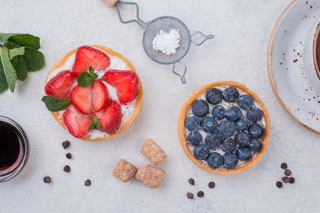 Foto gratuita vista dall'alto di crostate di frutta con zollette di zucchero