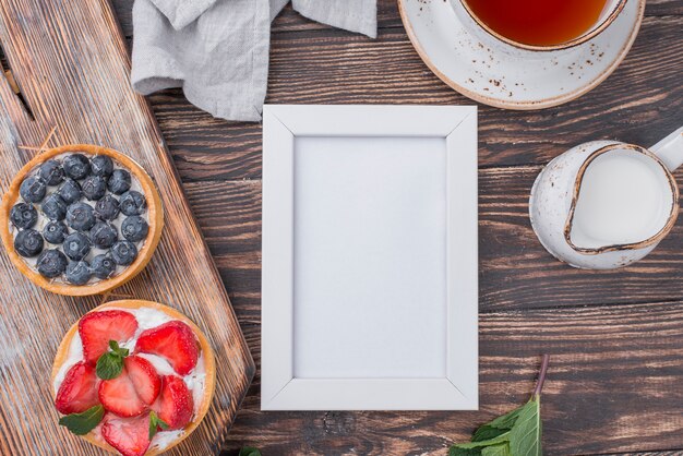 Free photo top view of fruit tarts with tea and frame