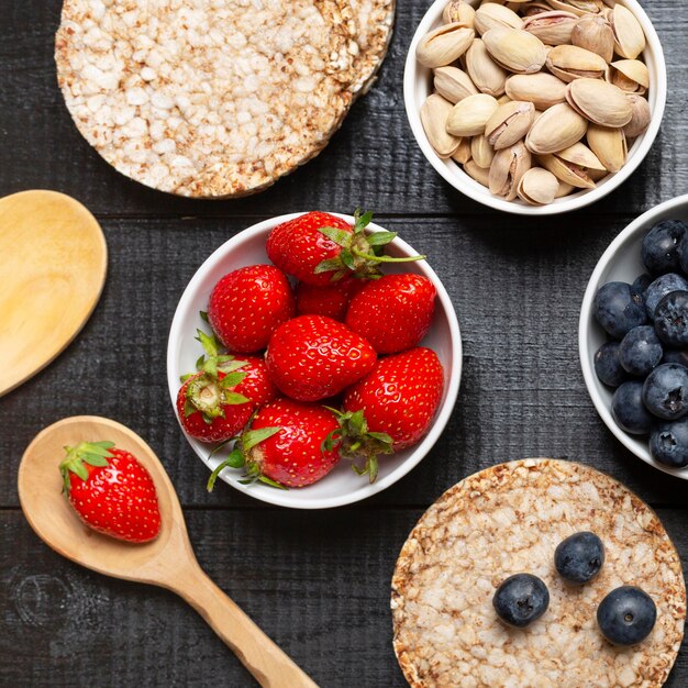 Top view fruits and pistachios in bowls