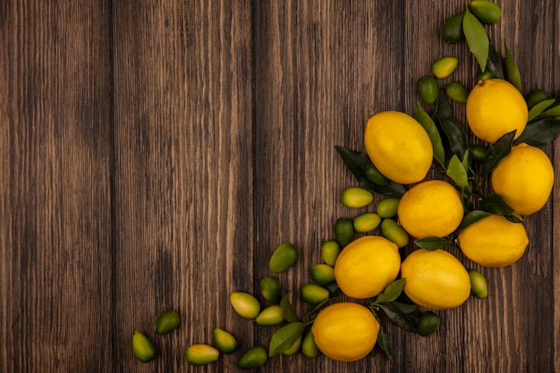Vista dall'alto di frutti come limoni e kinkan isolati su una superficie in legno con spazio di copia