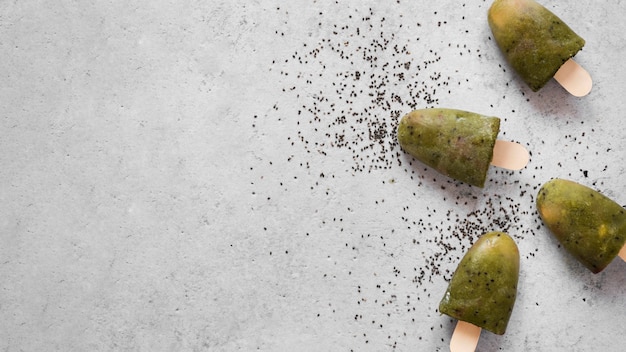 Top view of fruity popsicles with copy space and poppy seeds