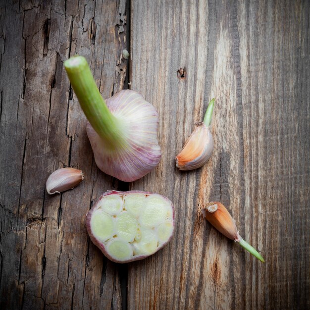 Top view garlic cut in a half on wooden background. vertical