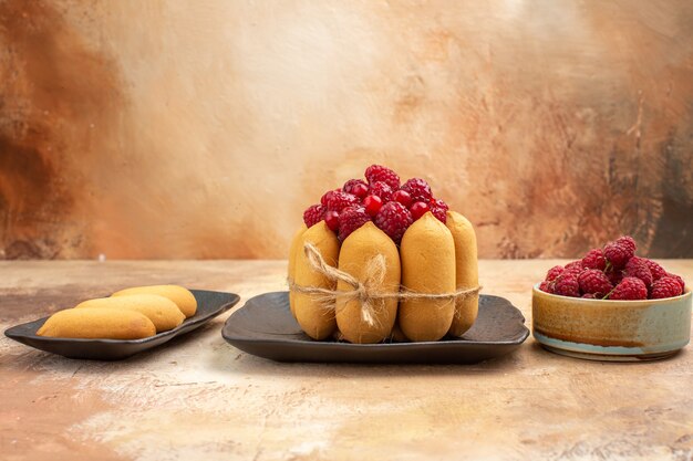 Top view of a gift cake fruit and biscuits on mixed color background