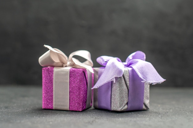 Вид сверху подарочные коробки розовые и фиолетовые с лентами на темном изолированном фоне свободного пространства