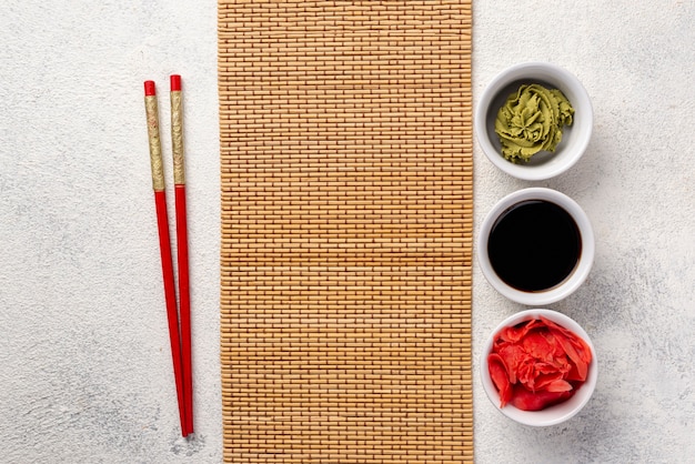 Foto gratuita vista dall'alto wasabi allo zenzero e ciotole di salsa di soia con copritavolo