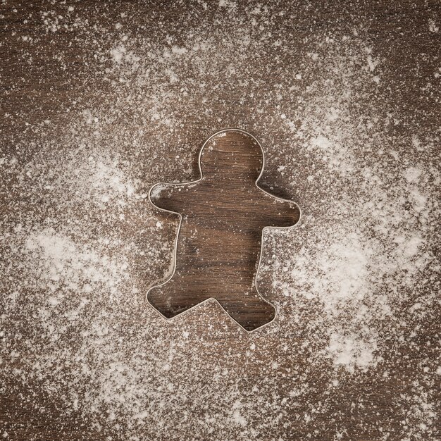 Top view gingerbread man cookie cutter with flour