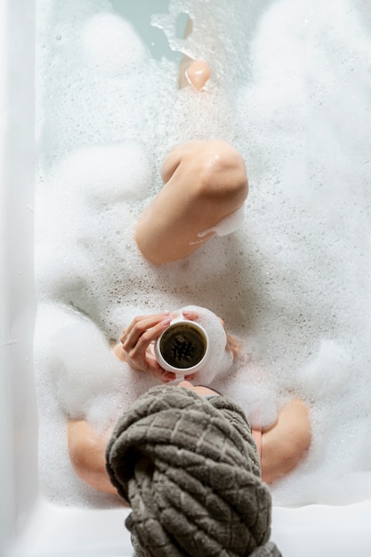 Top view girl in bathtub with foam