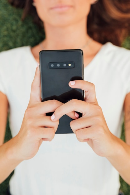 Ragazza di vista superiore che tiene telefono moderno