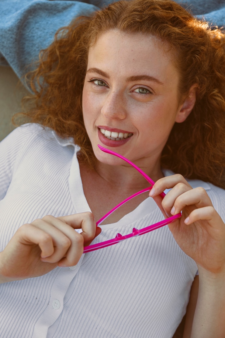 Free Photo top view girl holding pink sunglasses