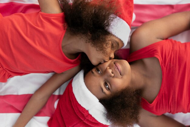 Top view girl kissing sister on cheek