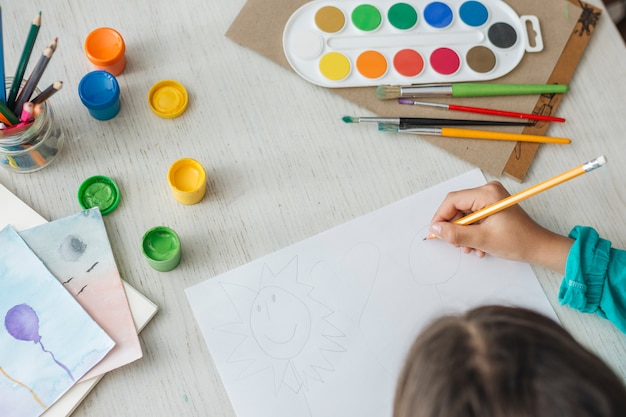 Top view of girl painting with watercolor