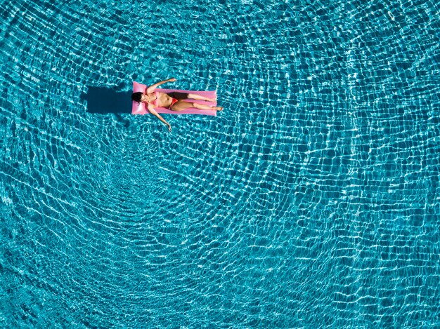 Top view of girl relaxing on inflatable mattress