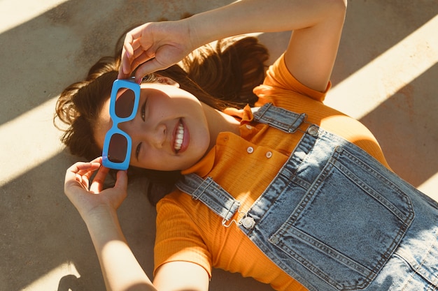 Free photo top view girl wearing blue sunglasses