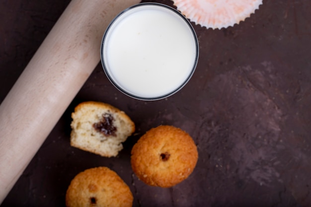 Top view of glass of milk with muffins on the table