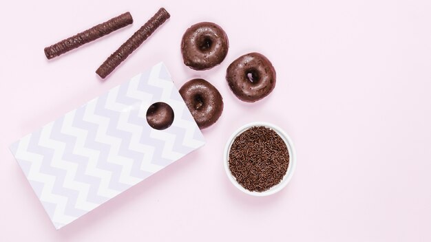 Top view glazed donuts and chocolate sticks