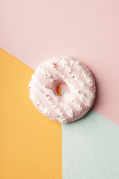 Top view of glazed doughnut with multicolored background