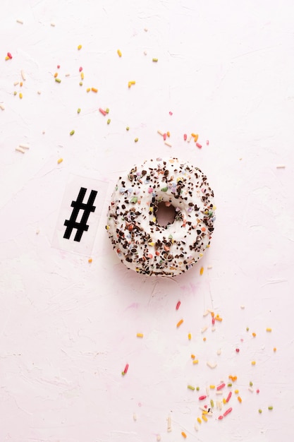 Top view of glazed doughnut with sprinkles and hashtag symbol