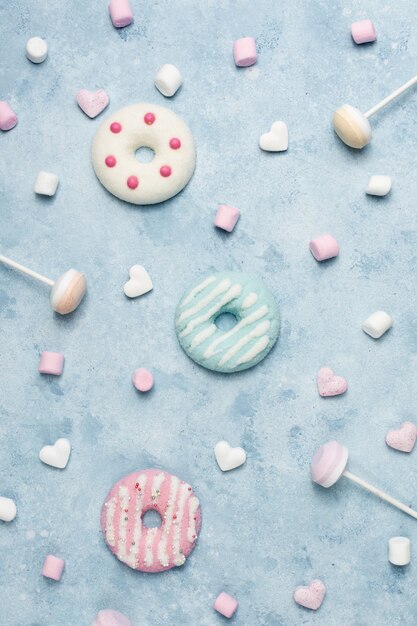 Top view of glazed doughnuts with candy and marshmallow