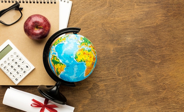 Top view of globe with diploma and copy space