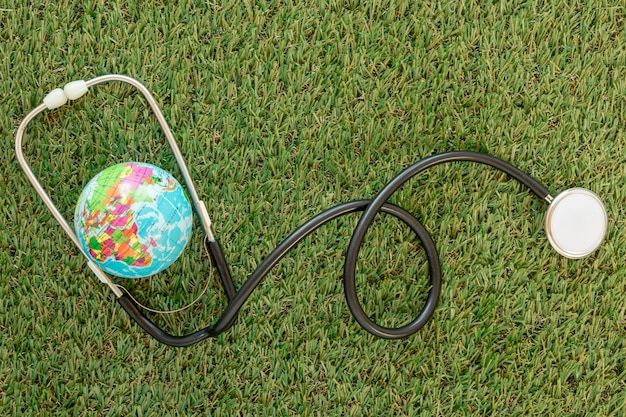 Top view globe with stethoscope on grass