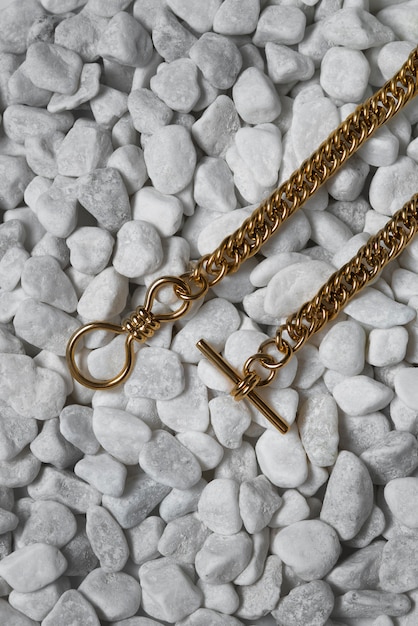 Top view gold chains on pebbles