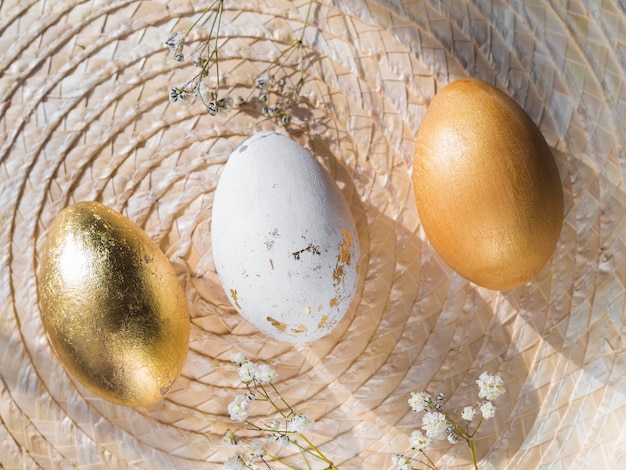 Foto gratuita vista superiore delle uova di pasqua colorate dorate su placemat