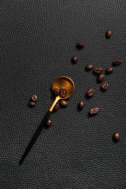 Top view of golden spoon with coffee beans