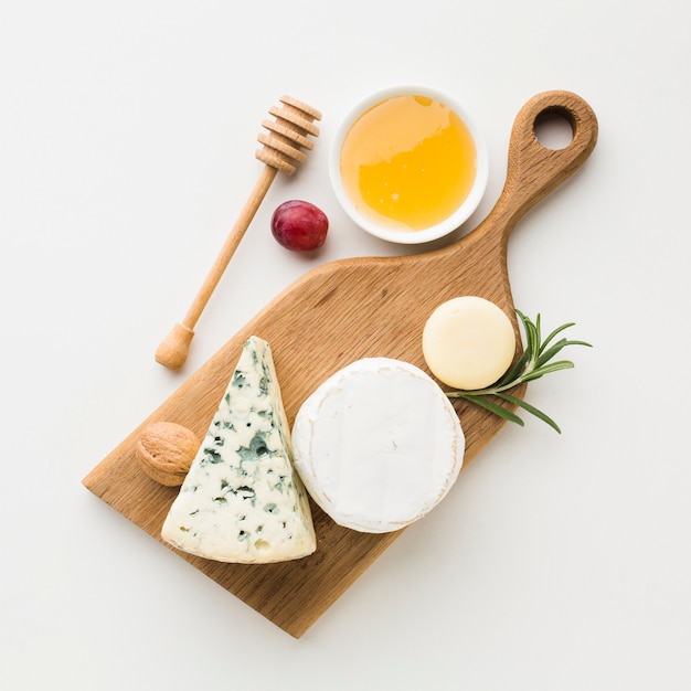 Top view gourmet assortment of cheese on wooden cutting board