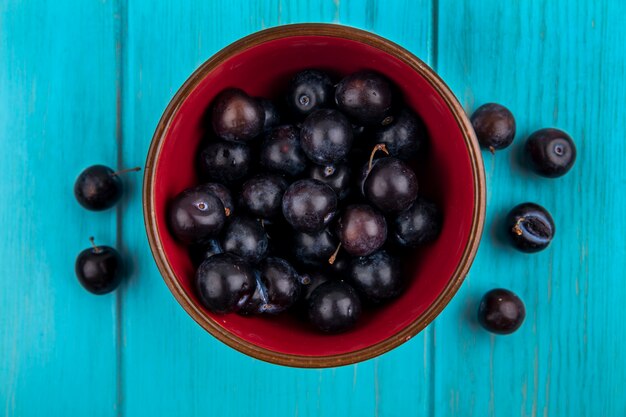 Вид сверху виноградных ягод в миске и на синем фоне