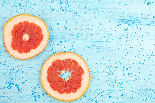 top view grapefruit sliced rings mellow ripe on the bright blue background