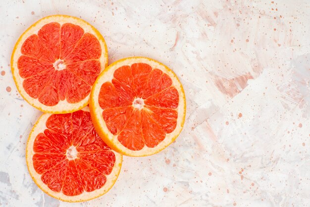 Top view grapefruits slices on nude surface with free space