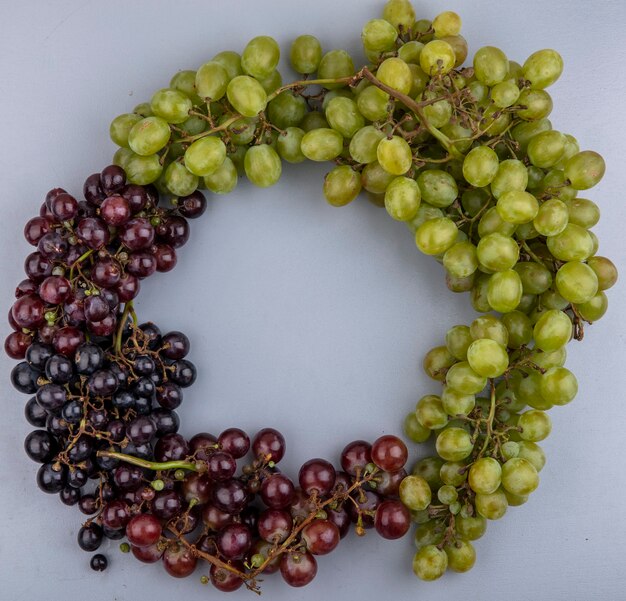 Free photo top view of grapes set in round shape on gray background with copy space