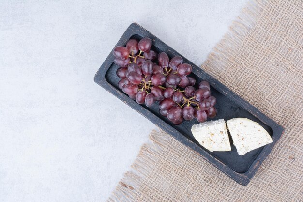 Top view of grapes with white cheese on sackcloth. High quality photo