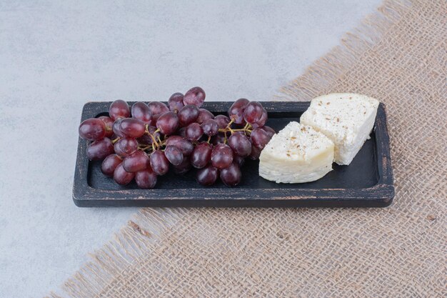 Top view of grapes with white cheese on sackcloth. High quality photo