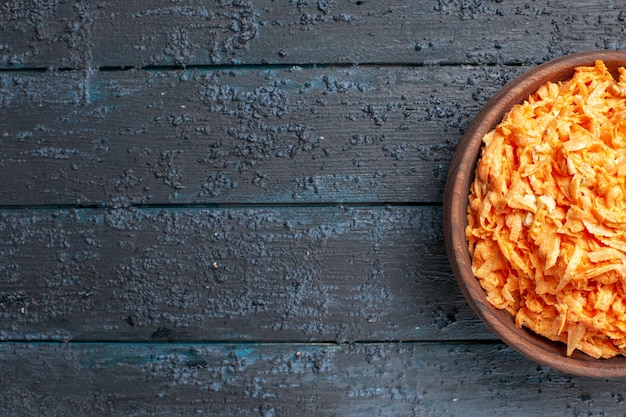 Top view grated carrot salad inside plate on dark-blue rustic floor salad color ripe health diet vegetable