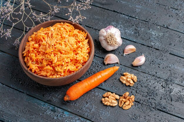 Top view grated carrot salad with garlic inside plate on the dark-blue rustic desk health salad ripe vegetable color diet