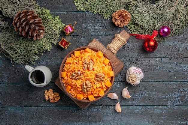 Top view grated carrot salad with walnuts on dark-blue background health food salad color diet nut