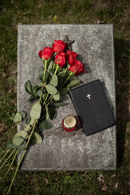 Top view of gravestone with flowers and candle