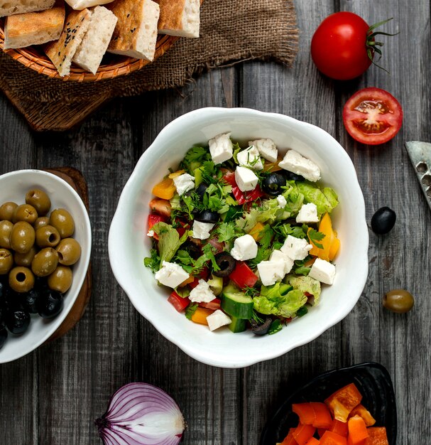 Top view of greek salad bowl with white cheese bell peppers cucumber and tomato