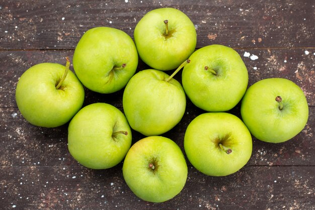 Вид сверху зеленые яблоки на коричневом деревянном столе свежее яблоко фрукты спелые